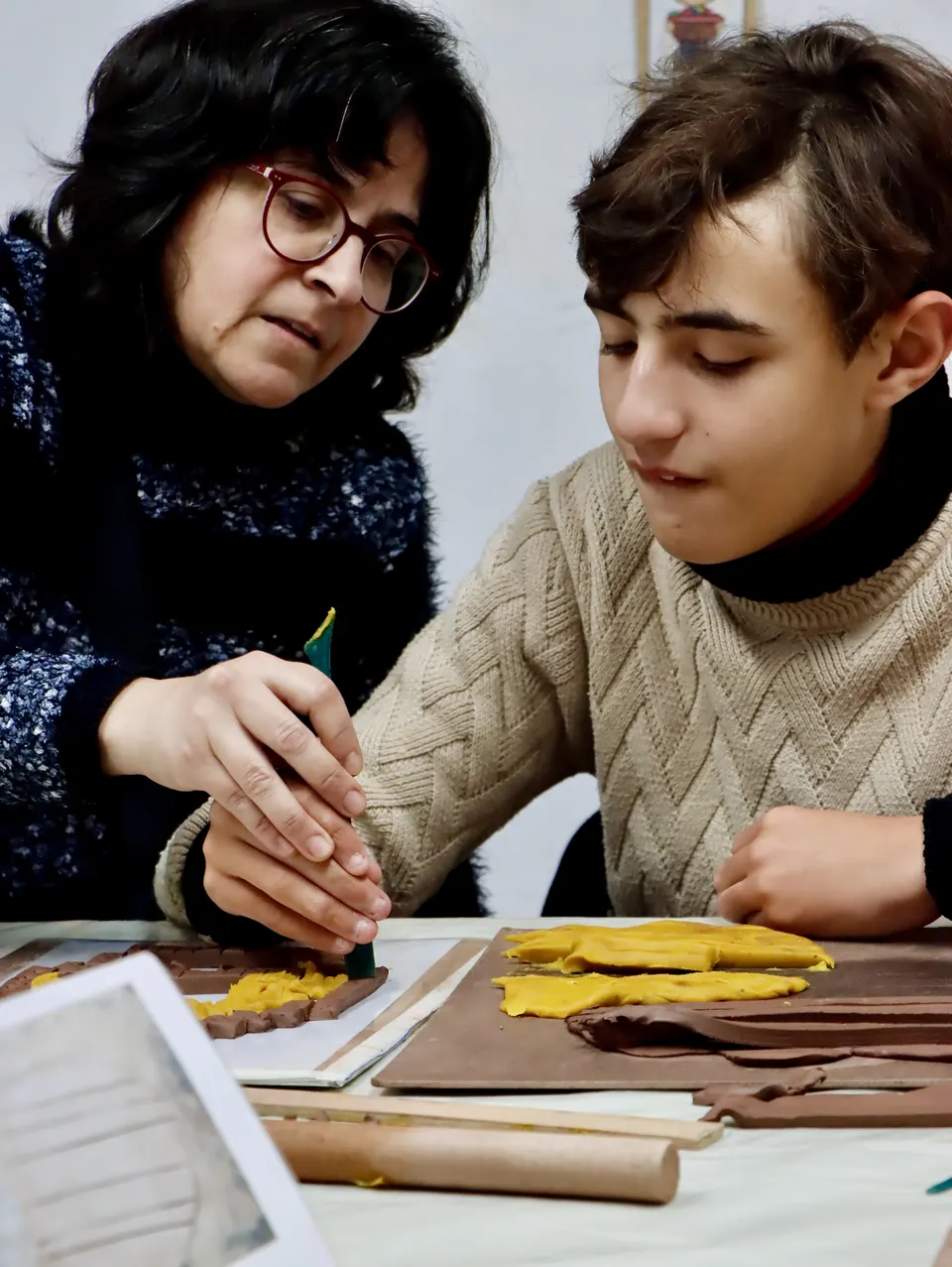 Una persona acompaña a un joven durante una actividad de modelado