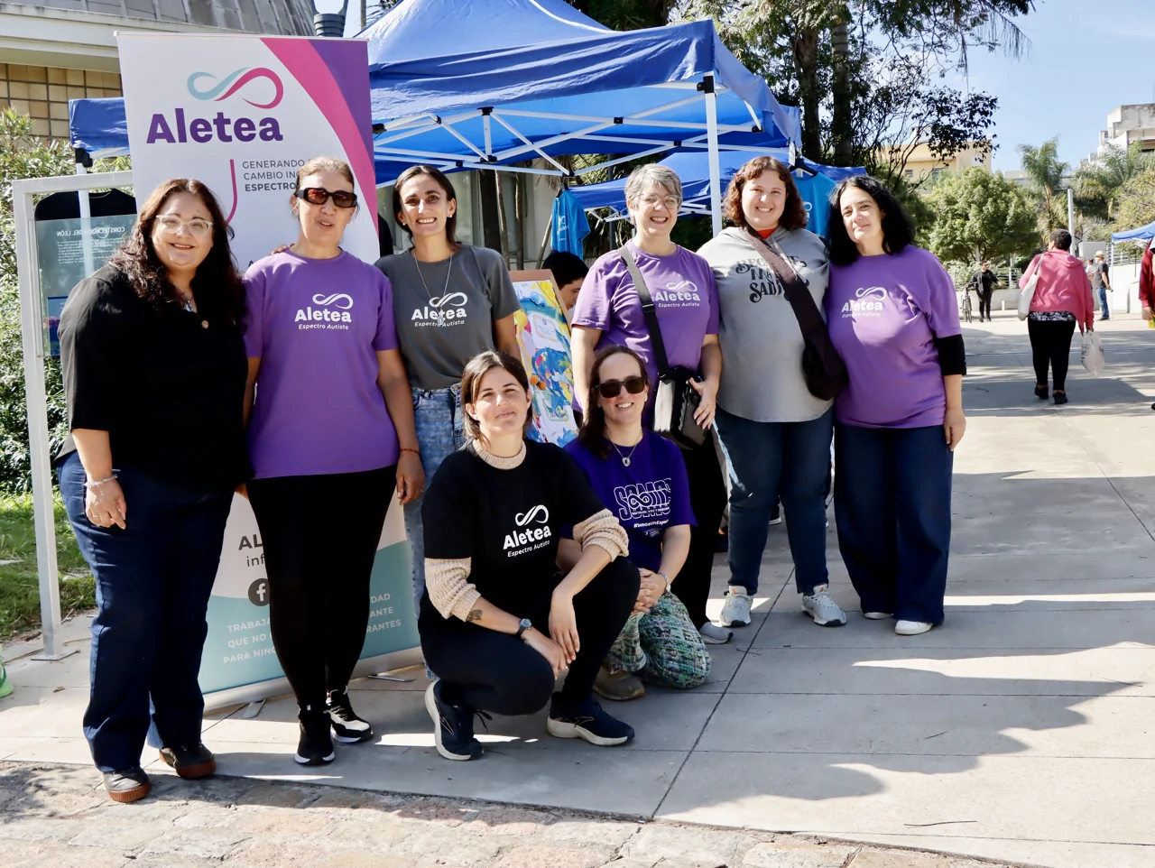 Grupo de personas junto al stand de Aletea, al aire libre.