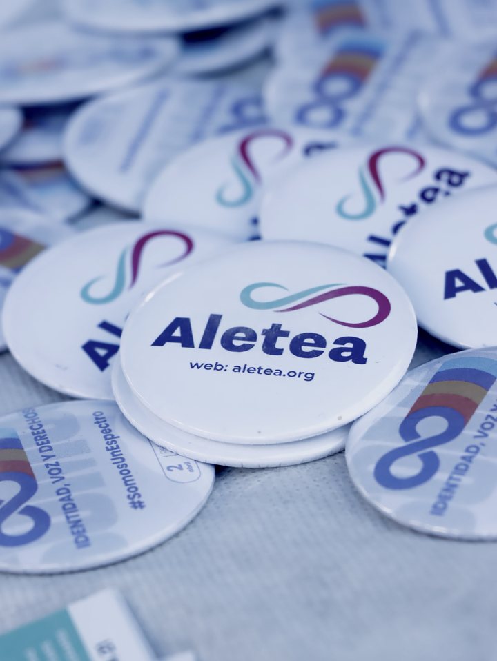 Detalle de prendedores blancos con el logo de Aletea y el mensaje Somos un Espectro.