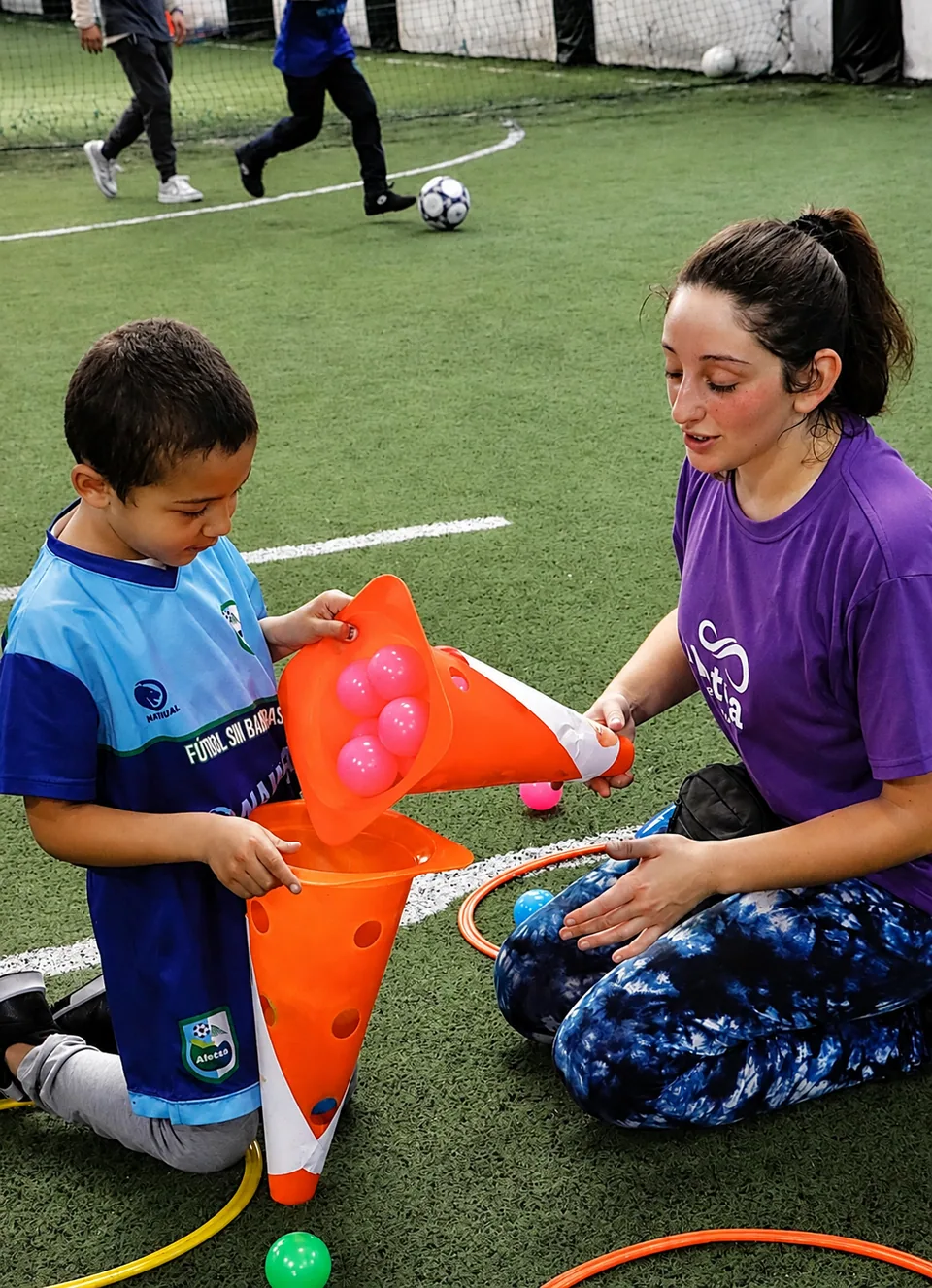 Un participante y una acompañante realizan una actividad adaptada con materiales de colores