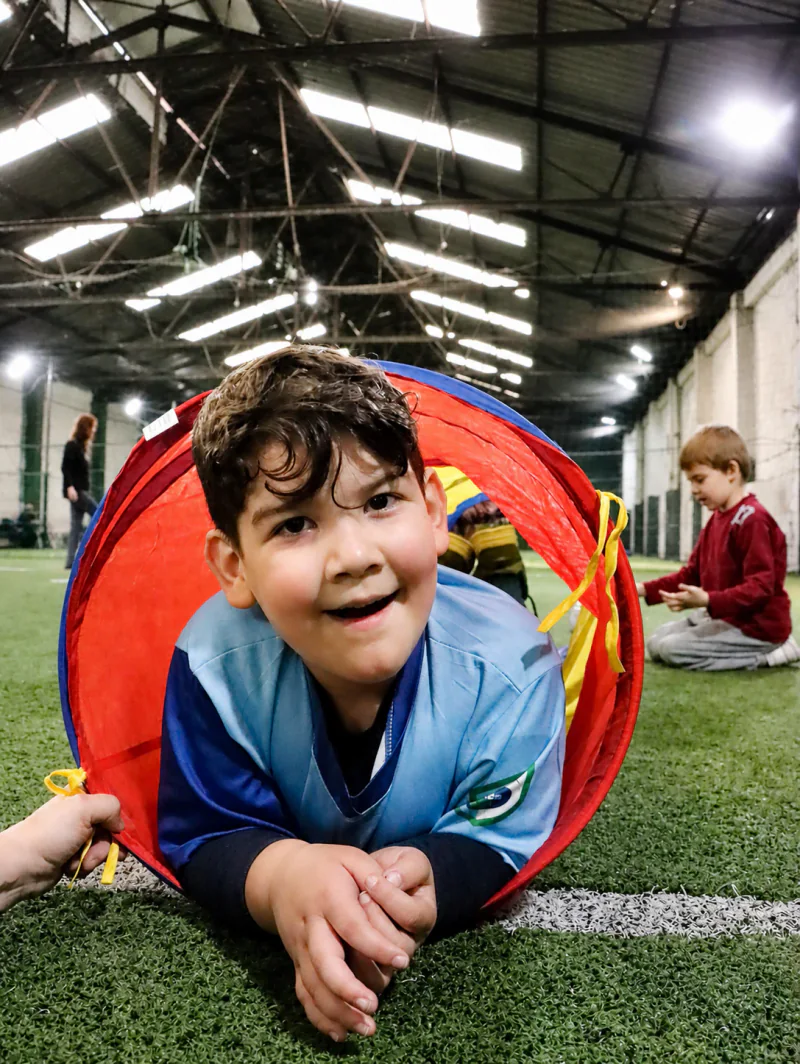 Un niño participa en una actividad de movimiento atravesando un túnel de juego