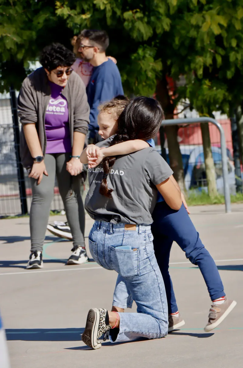 Una niña abraza a una persona adulta durante una actividad comunitaria de Aletea